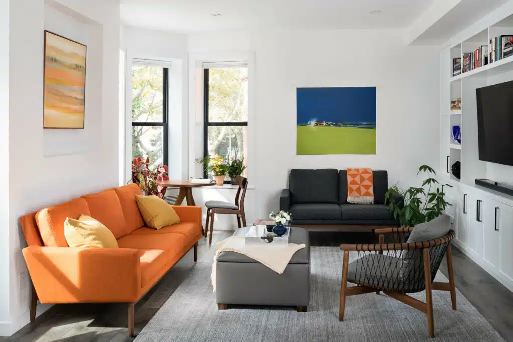 A living room with orange couches and a tv.