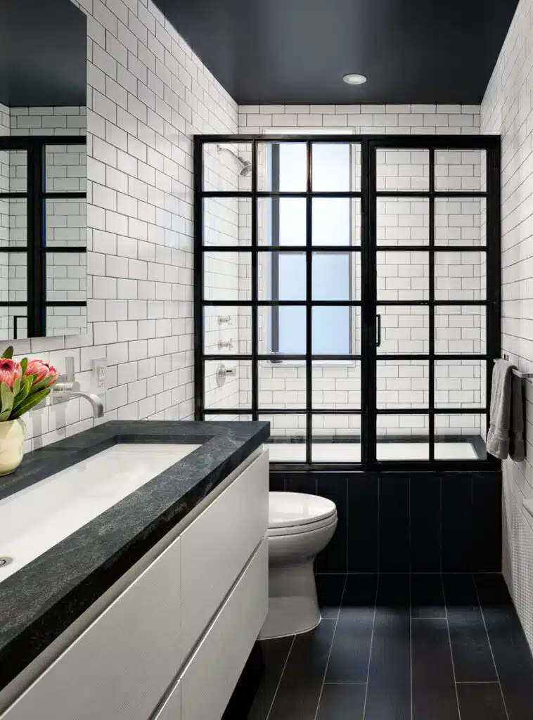 A black and white bathroom with tiled walls.