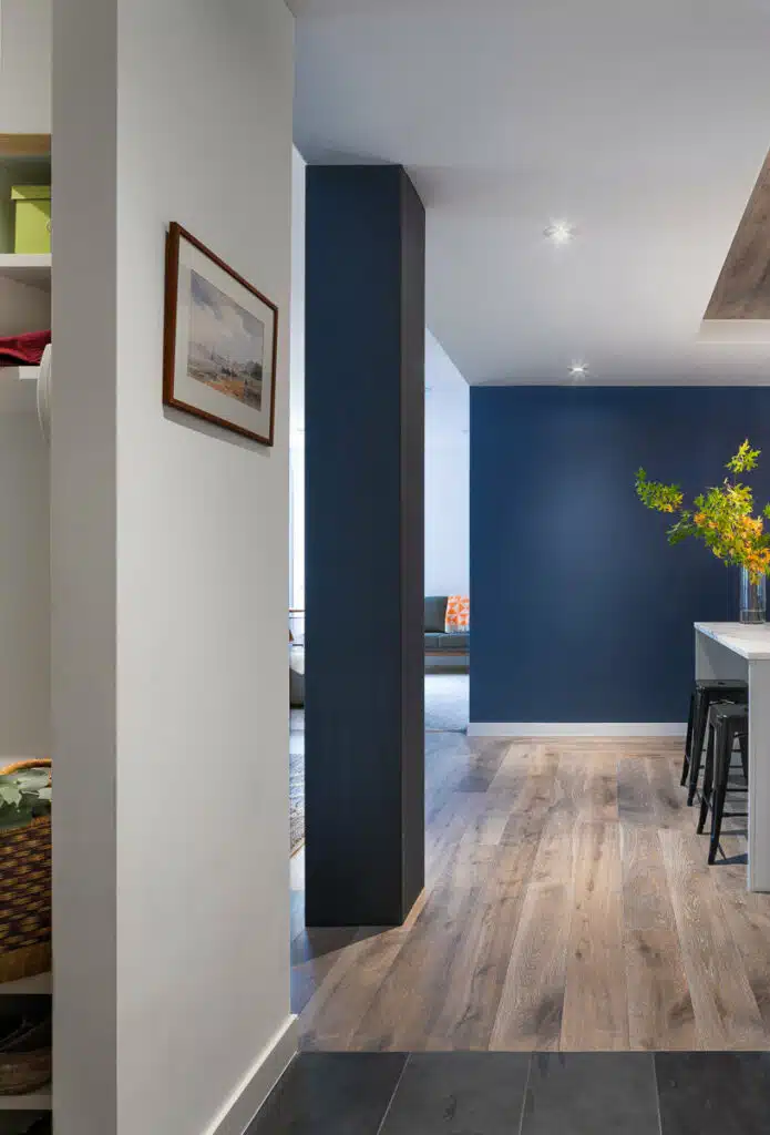 A kitchen with blue walls and wood floors.