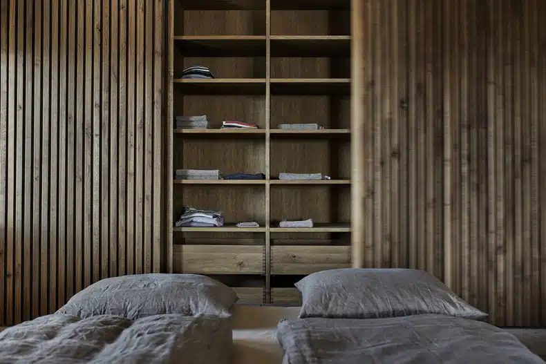 A bed in a room with wooden walls.