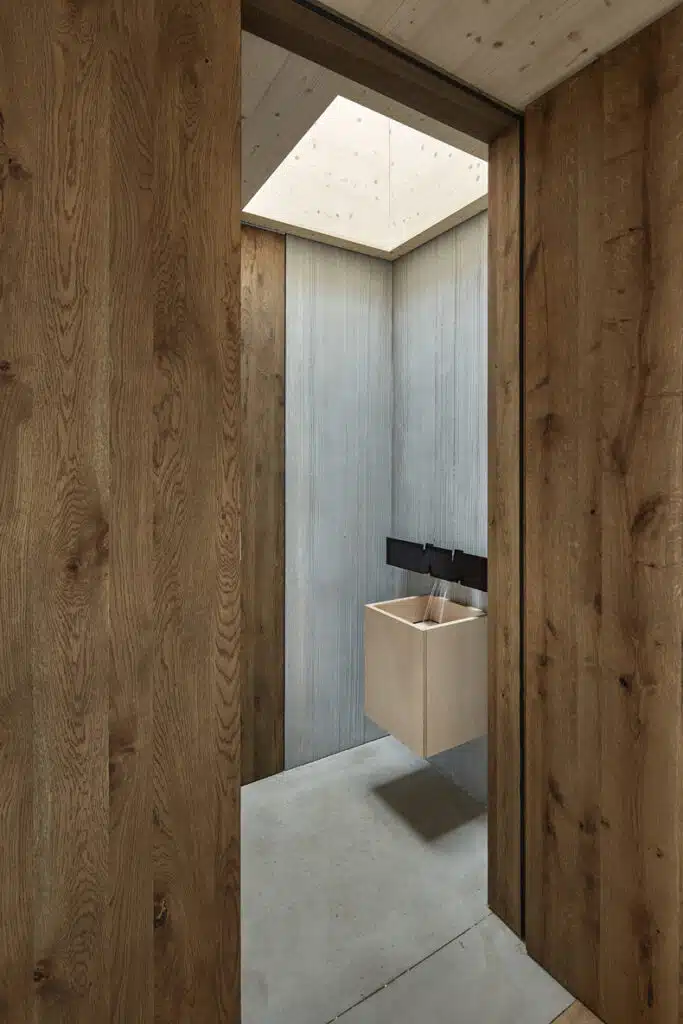 A bathroom with wooden walls and a sink.