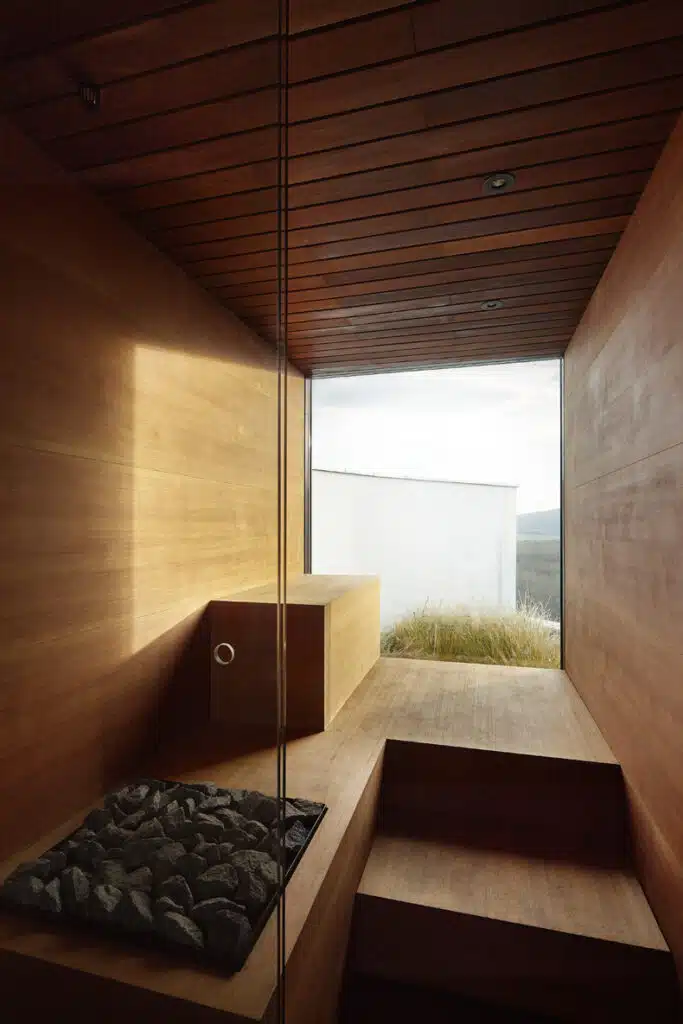 A wooden sauna room with a view of the mountains.