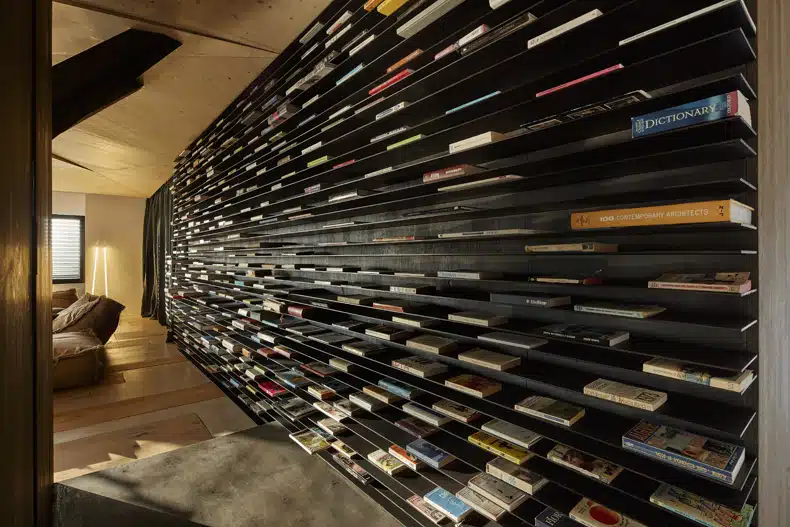 A room with a wall full of books.