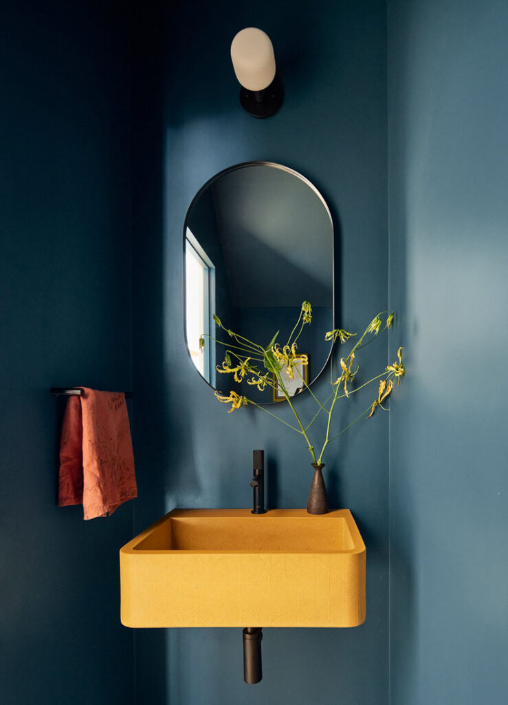 A yellow sink and blue walls in a bathroom of Sackett Street Townhouse.