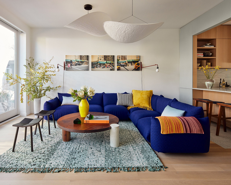 A living room with a blue couch and a coffee table at Sackett Street Townhouse designed by Barker Associates Architecture Office.