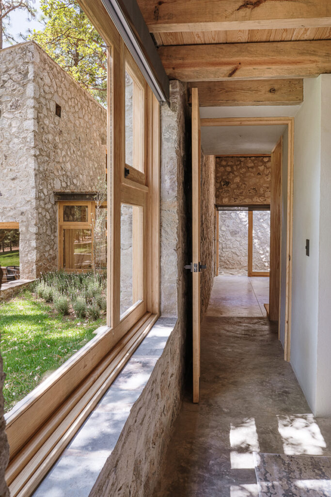 A Petraia House hallway showcasing a stone wall complemented by wooden beams.