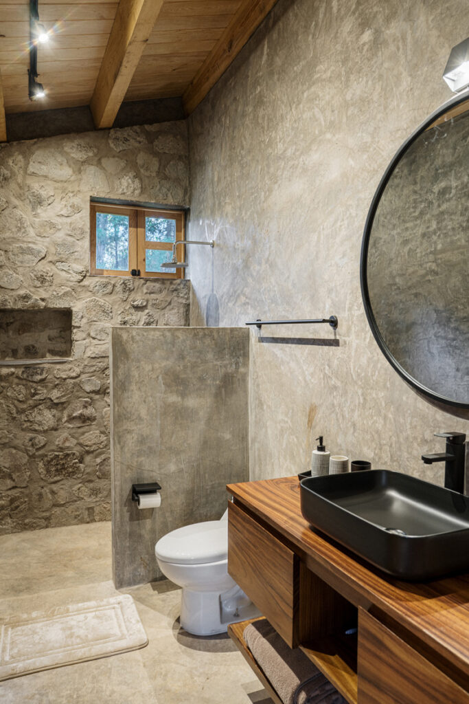 Petraia House By Argdl featuring a toilet, sink, and mirror.