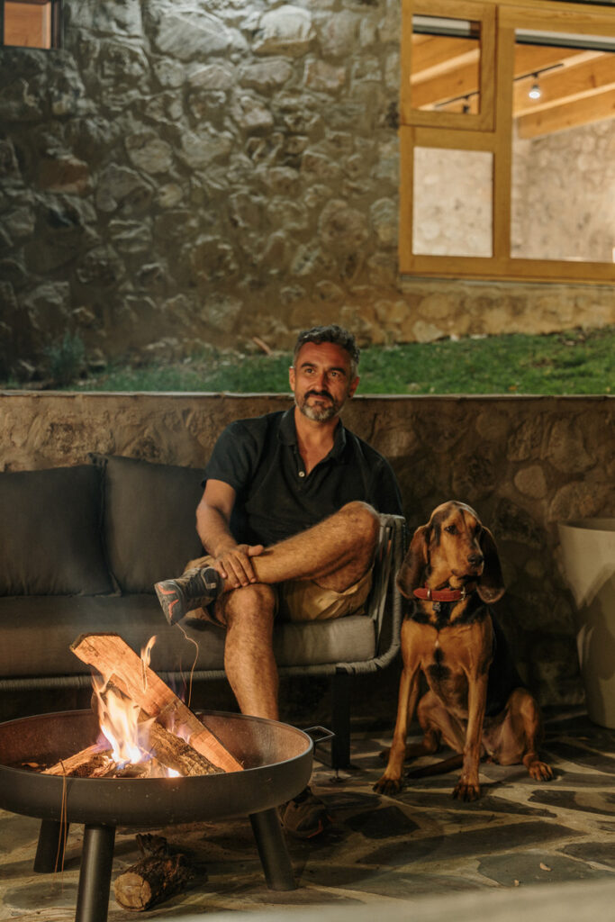 A man enjoying the cozy ambiance of a fire pit in Petraia House.