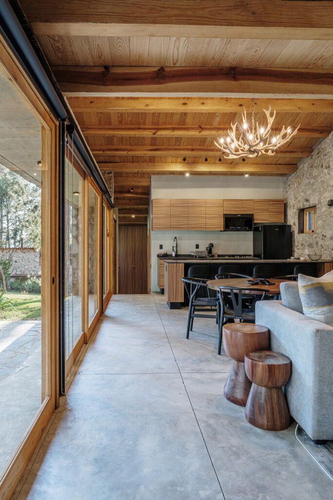 Petraia House by Argdl features a living room and dining room with exquisite wooden ceilings.