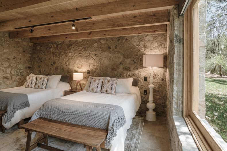 Petraia House by Argdl: Stone-walled room with two beds.