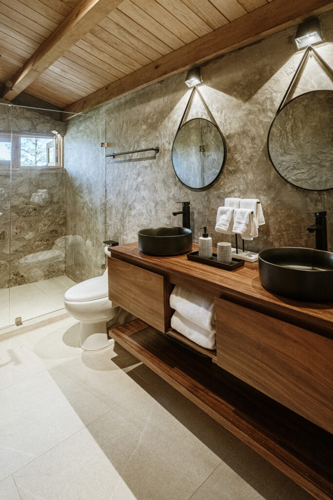 Petraia House By Argdl features a bathroom with two sinks and a glass shower.