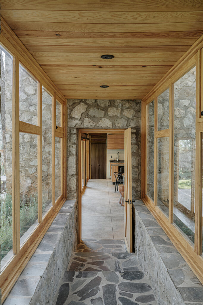 A hallway with stone walls and windows in Petraia House.
