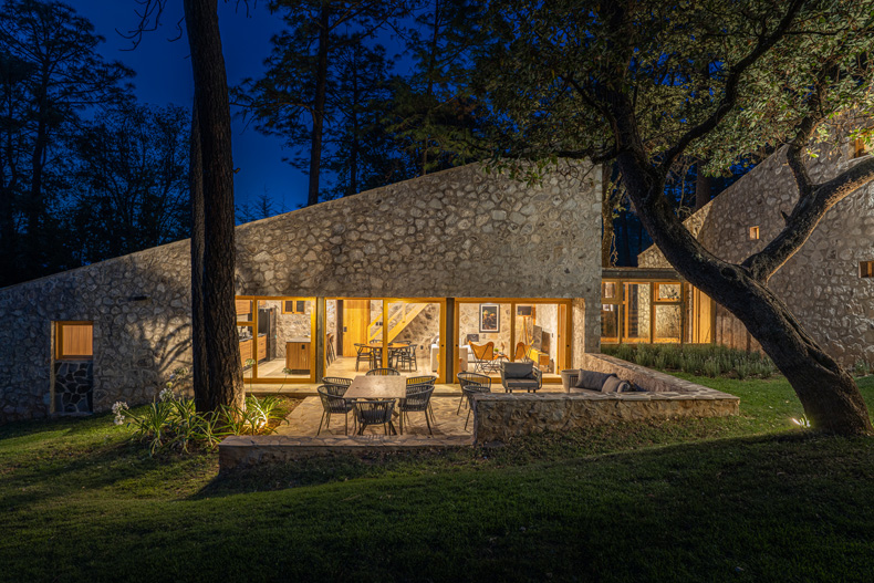 Petraia House, a stone house in the woods at night.