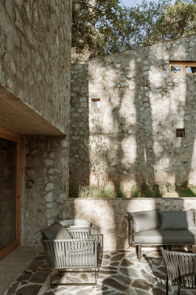 A Petraia House with a stone patio and furniture.