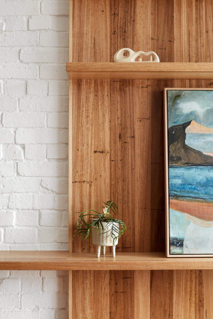 A wooden shelf displaying the painting "Through The Looking Glass" by Ben Callery Architects.