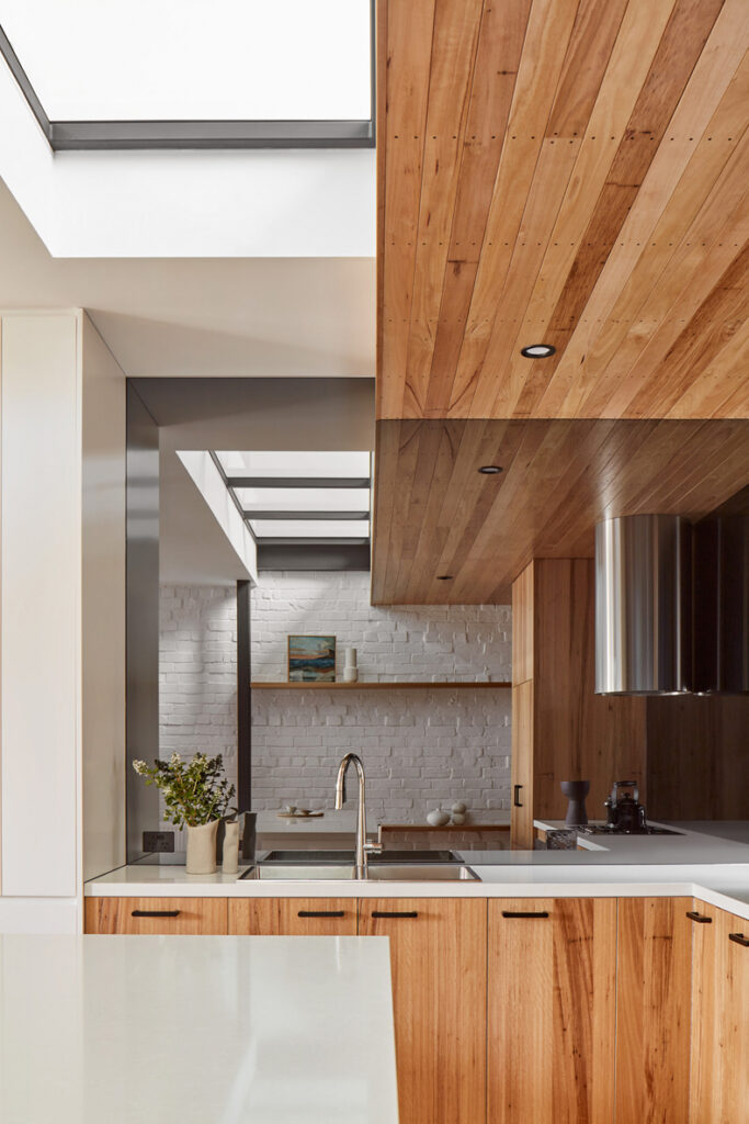Through The Looking Glass By Ben Callery Architects: A modern kitchen with wood cabinets and a skylight.
