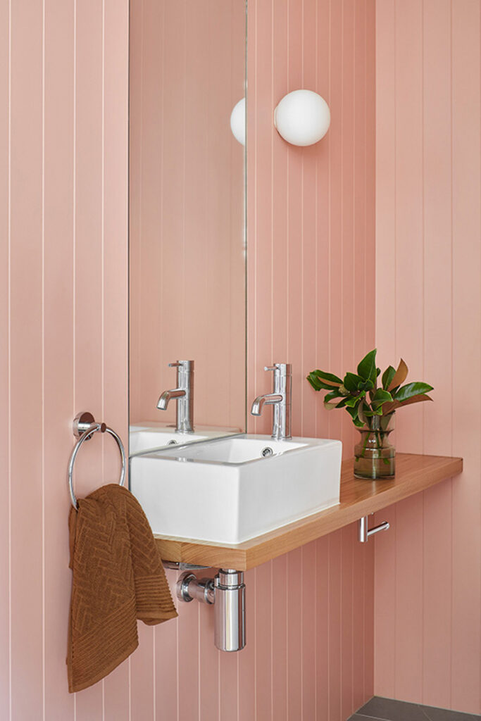 Twin Peaks House By Mihaly Slocombe, featuring a pink-walled bathroom with a sink.