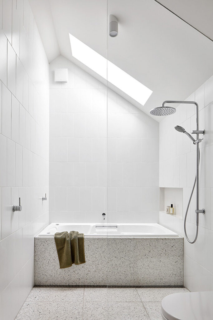 Twin Peaks House By Mihaly Slocombe showcases a bright bathroom with a skylight.