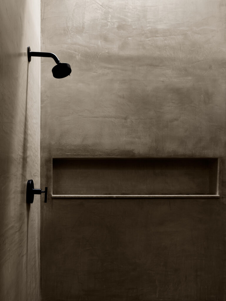 A black and white photo of a bathroom with a shower head.