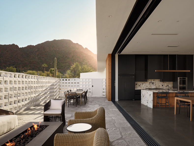 A modern patio with a fire pit and a view of the mountains.
