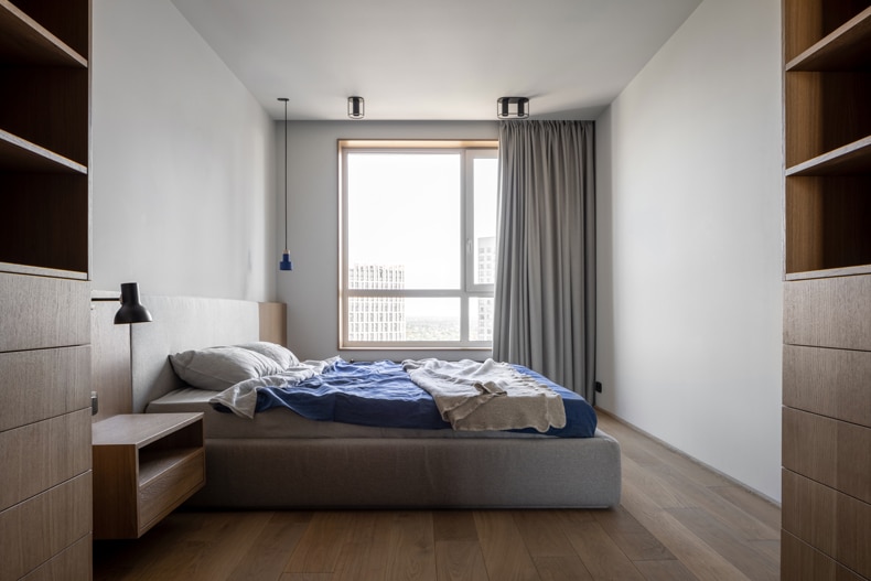 A Zaricnyy apartment featuring wooden floors and a blue comforter.
