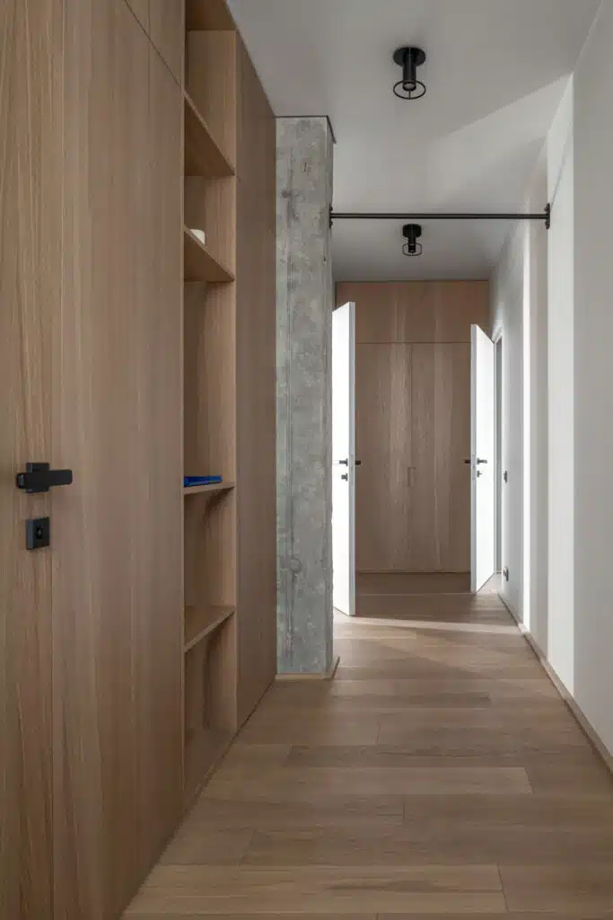 Zaricnyy Apartment: A hallway with wooden cabinets and a wooden floor.