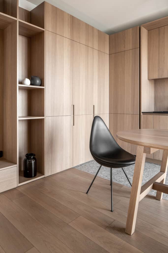 A room with wooden cabinets and a black chair in Zaricnyy Apartment By Kouple.