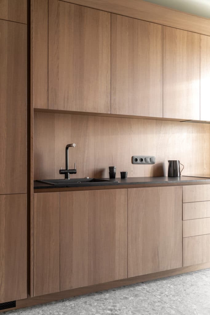 Zaricnyy Apartment, a modern kitchen with wooden cabinets.