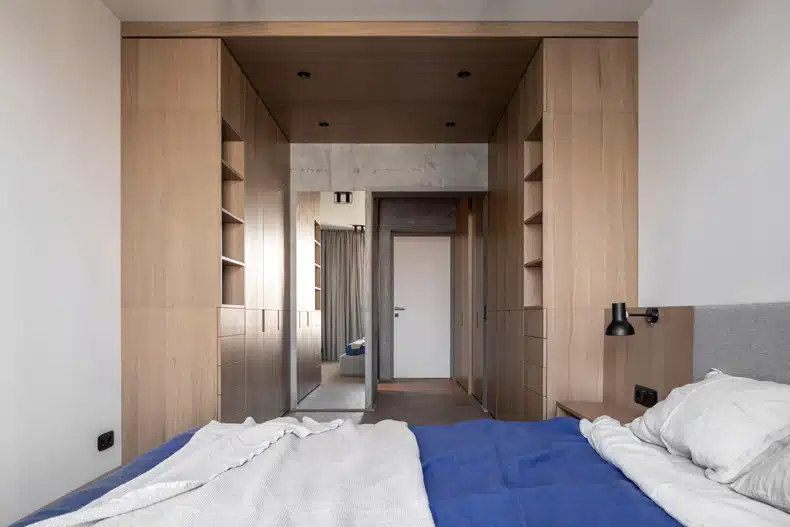 A bedroom with wooden cabinets and a blue comforter in Zaricnyy Apartment.