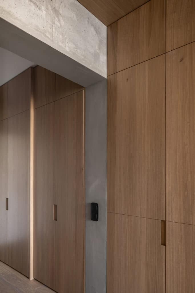 Zaricnyy Apartment: A hallway with wooden doors and concrete walls.