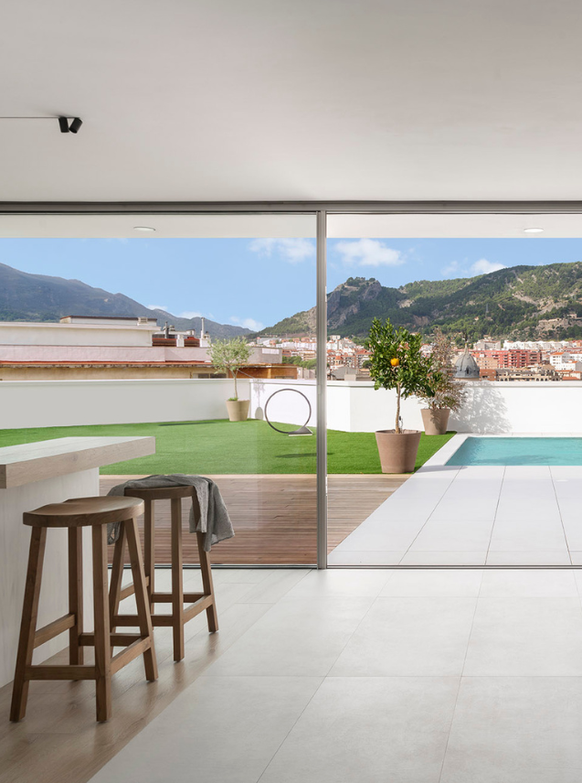 Citric House by Susanna Cots Interior Design features a white kitchen overlooking the pool and mountains.