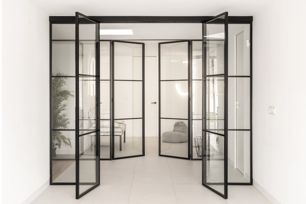 A glass door leading into a white room at Citric House by Susanna Cots Interior Design.