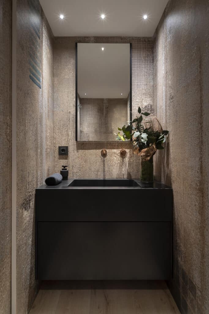 A modern bathroom in the Citric House with a black sink and mirror.