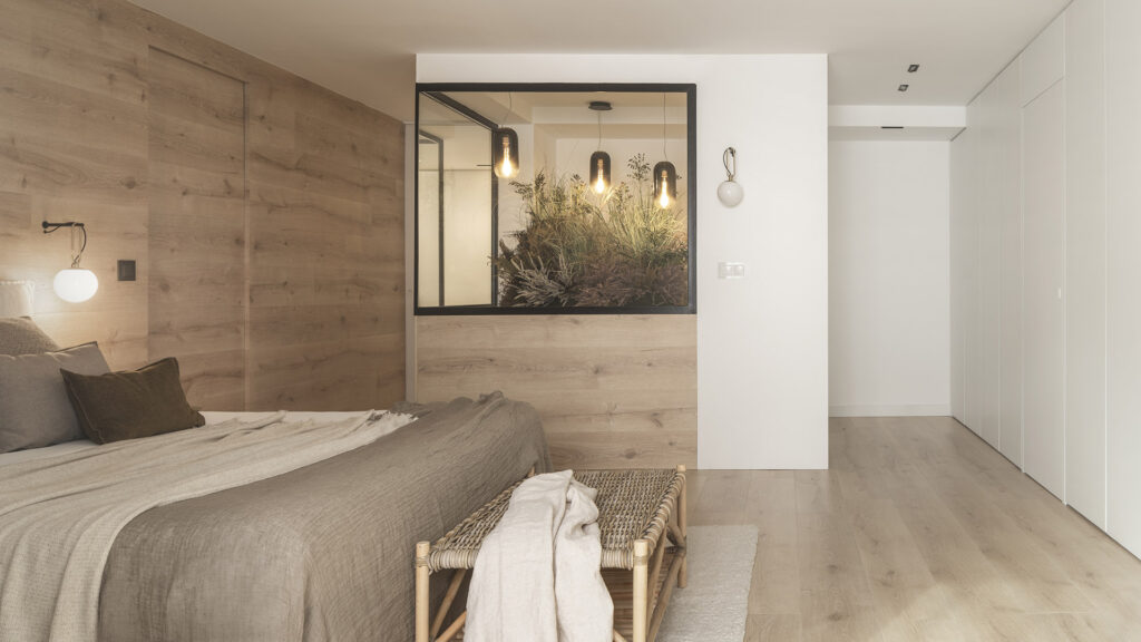 Citric House by Susanna Cots Interior Design features a bedroom with wooden walls and a bed.