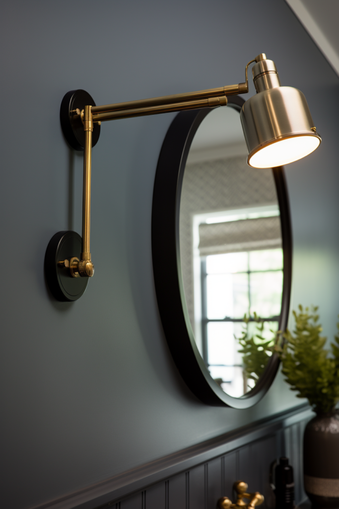 A bathroom with a gold wall light and a mirror, utilizing vertical space for storage.