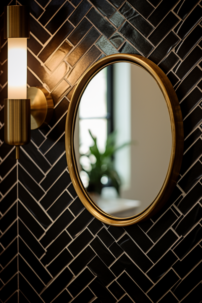 A rustic round mirror on a black and gold tiled bathroom wall.